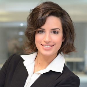 a smiling woman with short hair wearing a blouse with collar